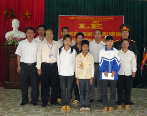 Đại diện Ban CHQS huyện Cao Phong trao học bổng cho các em học sinh.